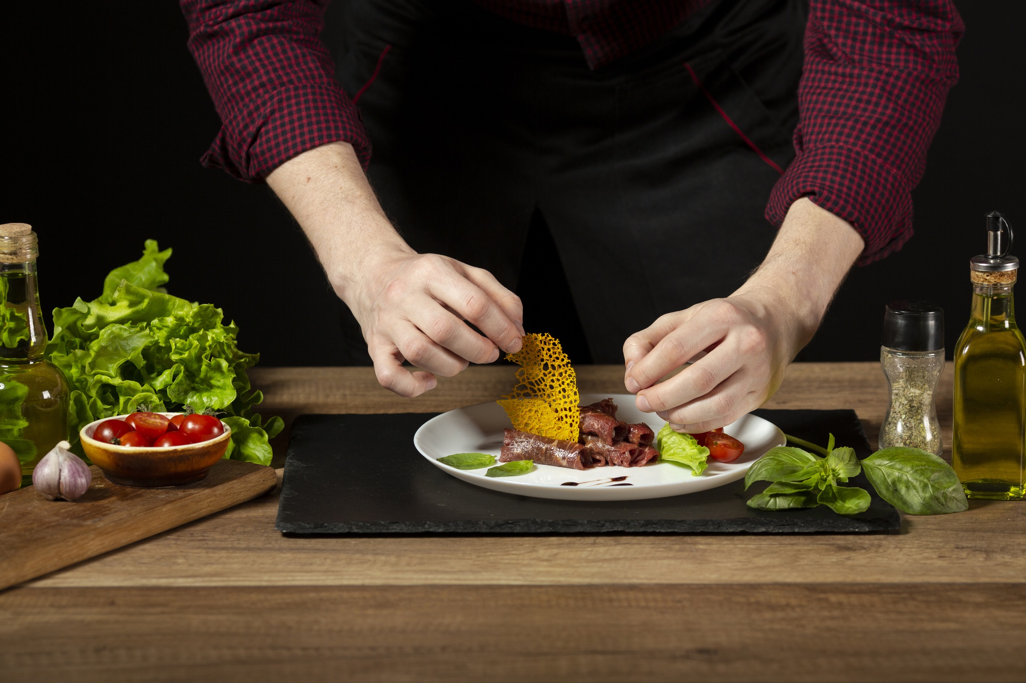 Hands seasoning plated dish on counter